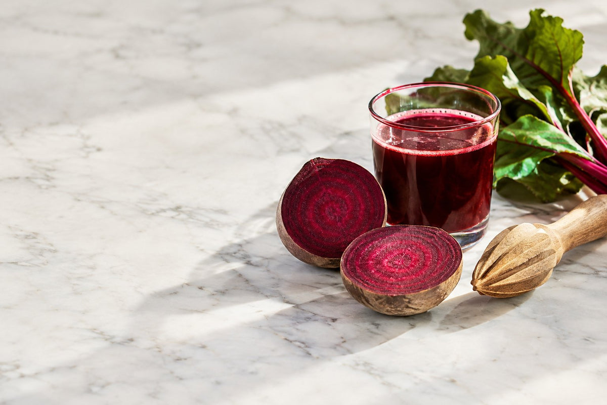 Halved beets, amber dropper bottle and coffee in morning light: beetroot benefits for women over 40