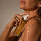 Woman applying ADIRA Botanical Body Oil to her shoulder